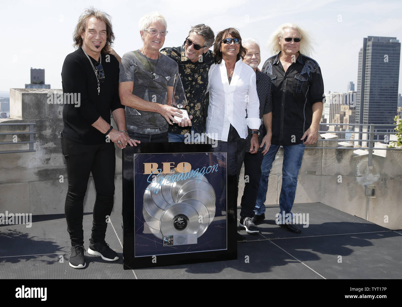 Dave Amato, Kevin Cronin, Mark Goodman, Bryan Hitt, Neal Doughty and Bruce Hall of REO Speedwagon stand on the Sony Music rooftop when the 1980 album 'Hi Infidelity'  is awarded a Recording Industry Association of America RIAA 10X Diamond Award for surpassing 10 million units in the United States on August 17, 2017 in New York City. Hi Infidelity is the ninth studio album by the band REO Speedwagon, it was released on November 21, 1980. The album became a big hit in the United States peaking at number one on the Billboard 200 REO Speedwagon accepts the award from RIAA, Legacy Recordings and So Stock Photo