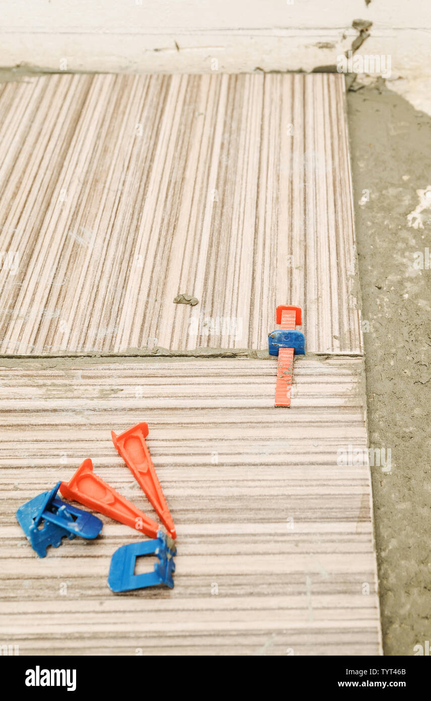 Plastic wedges and clips on ceramic tiles. Tile Spacer Leveling System. Stock Photo