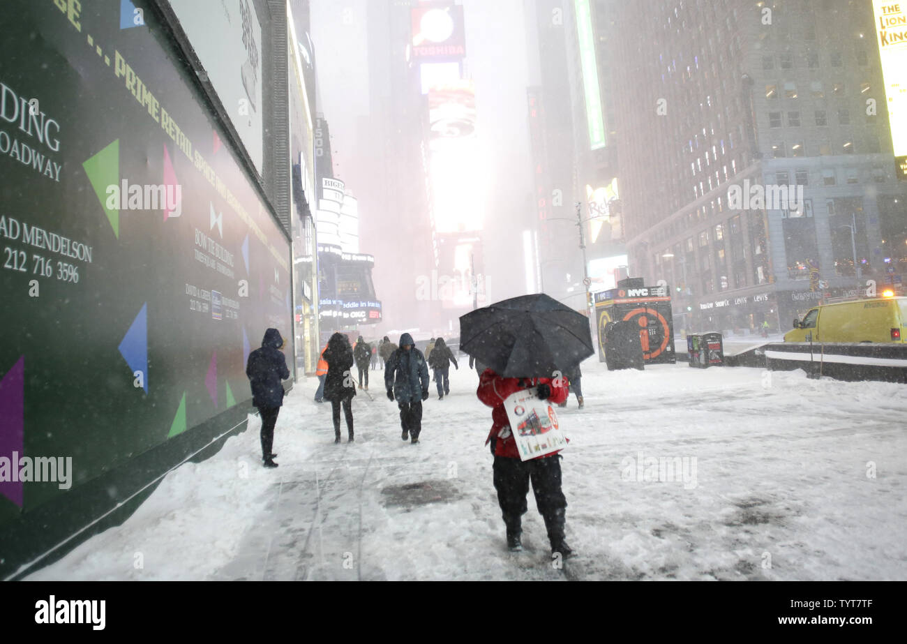 Pedestrians bundled up for cold weather walk in Times Square in below  freezing temperatures in New York City on January 4, 2018. A massive winter  storm called a "bomb cyclone" is hitting