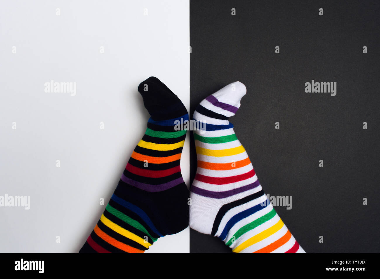 Funny legs with white and black striped new clean colorful textile socks. Fashion accessories for feet with negative background with copy space. Flat Stock Photo