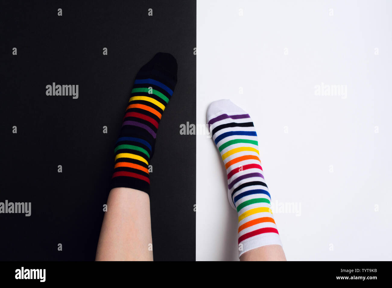 Two nagative legs with white and black striped colorful socks with negative background with copy space. Flat lay Stock Photo