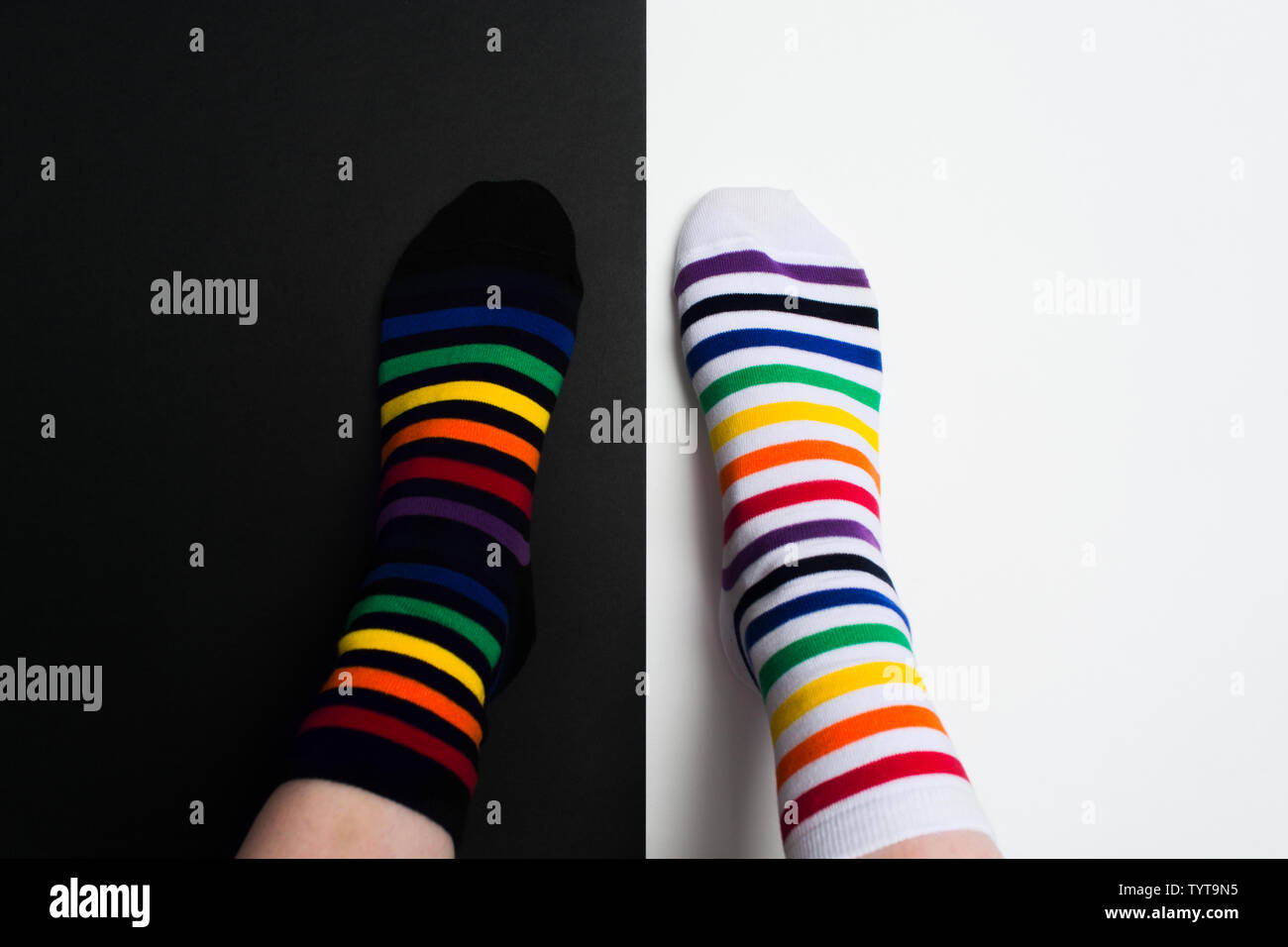 Legs with white and black striped new clean colorful textile socks. Fashion accessories for feet with negative background with copy space. Flat lay Stock Photo