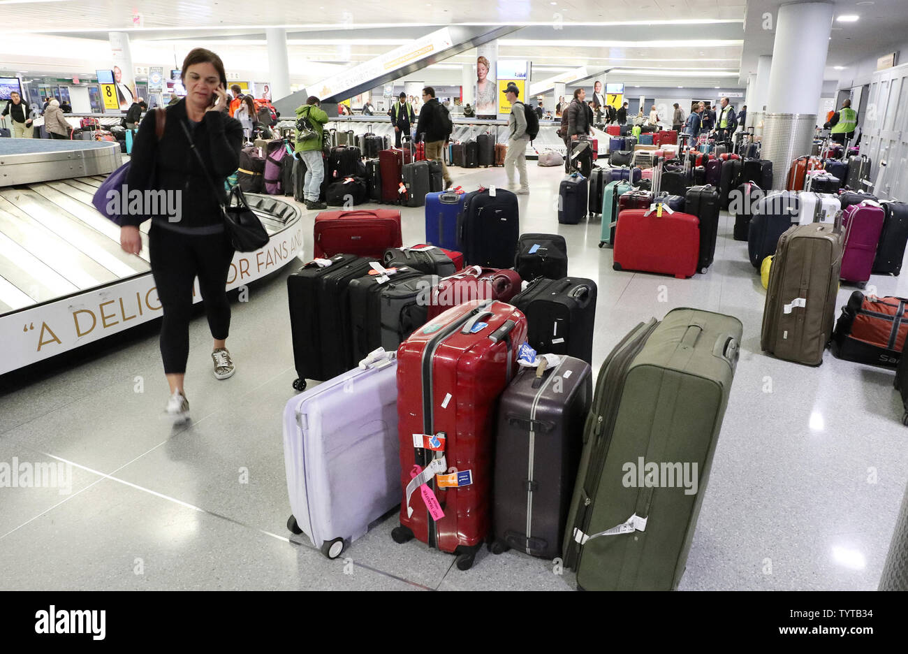 Travelers walk among sections of unclaimed luggage at baggage claim on a day where flights were canceled do to bad weather at JFK Airport in New York City on March 2, 2018. A Nor'easter slamming the Tri-State Friday grounded flights at John F. Kennedy Airport and forced airlines to cancel hundreds of flights at other area airports. More than 1,500 flights at the three major airports were grounded.     Photo by John Angelillo/UPI Stock Photo