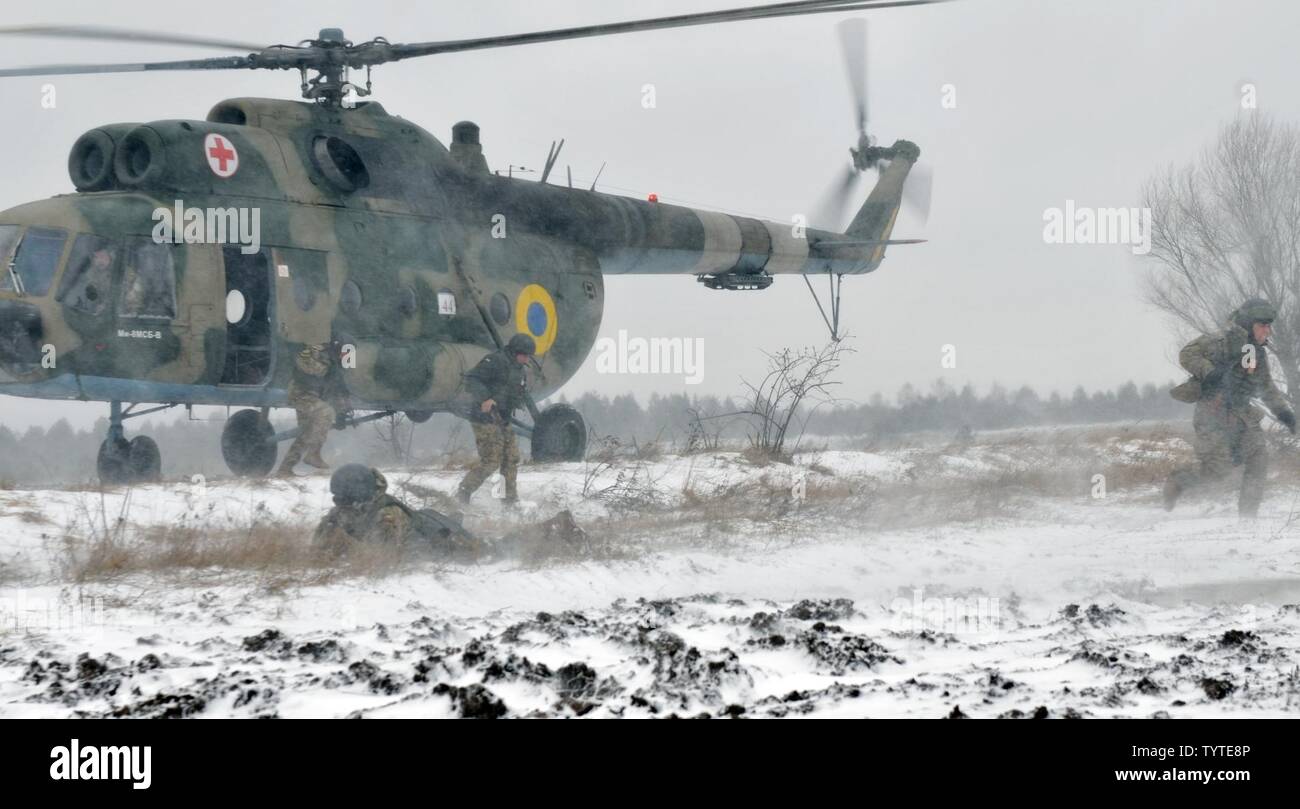 Ukrainian Soldiers assigned to 1st Battalion, 80th Airmobile Brigade dismount from a Mi-8 helicopter for an air assault mission in conjunction with a situational training exercise led by Soldiers from 6th Squadron, 8th Cavalry Regiment, 2nd Infantry Brigade Combat Team, 3rd Infantry Division, Nov. 28, 2016, at the International Peacekeeping and Security Center. This training is part of their 55-day rotation with the Joint Multinational Training Group-Ukraine. JMTG-U is focused on helping to develop an enduring and sustainable training capacity within Ukraine. Stock Photo