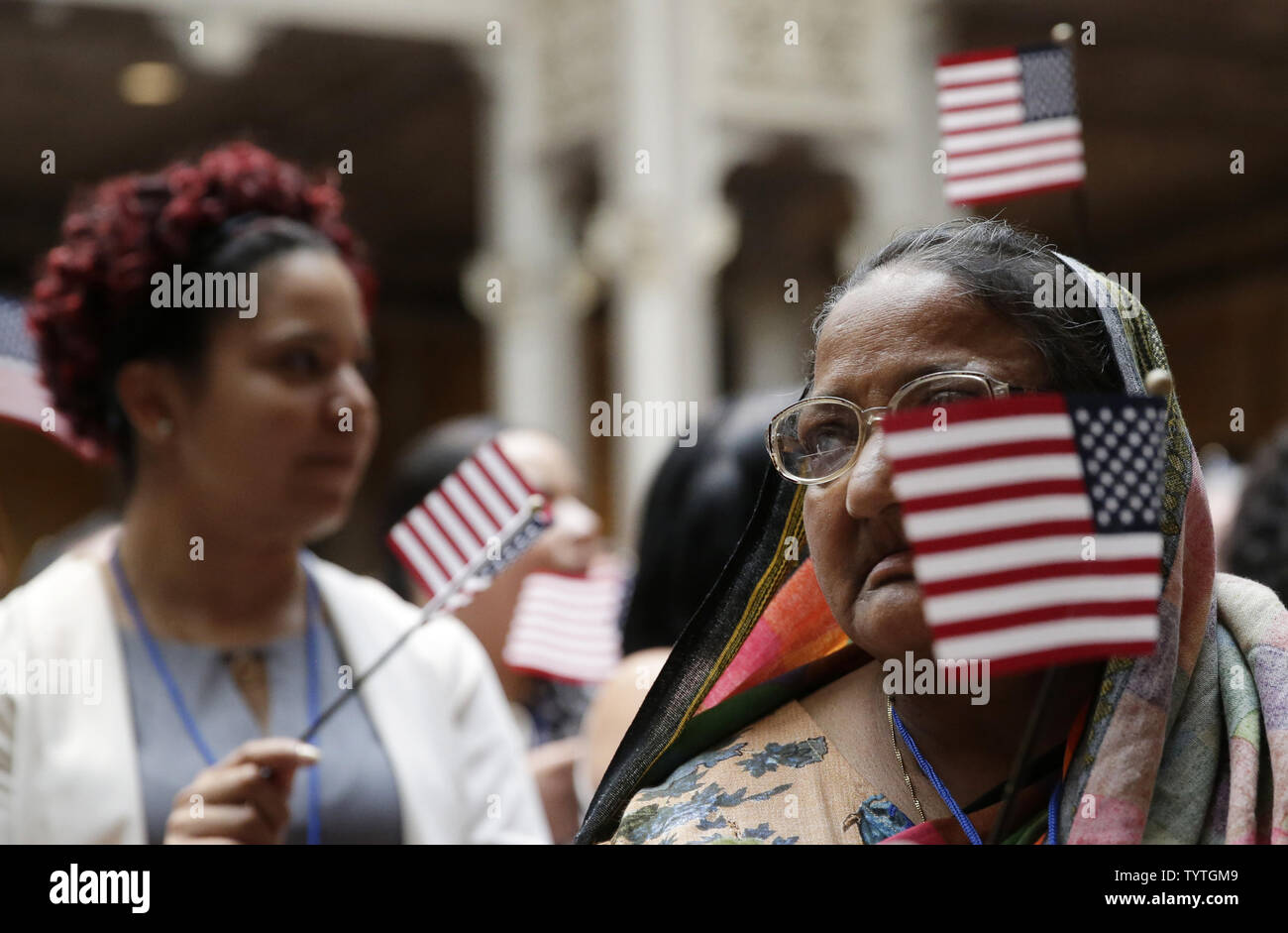 New citizens of the United States hold American Flags when U.S. Citizenship and Immigration Services (USCIS) administer the Oath of Allegiance to America's newest citizens during a special naturalization ceremony at the Stephen A. Schwarzmann Building of the New York Public Library in New York City on July 3, 2018. The ceremony is part of USCIS' annual Independence Day celebration.       Photo by John Angelillo/UPI Stock Photo