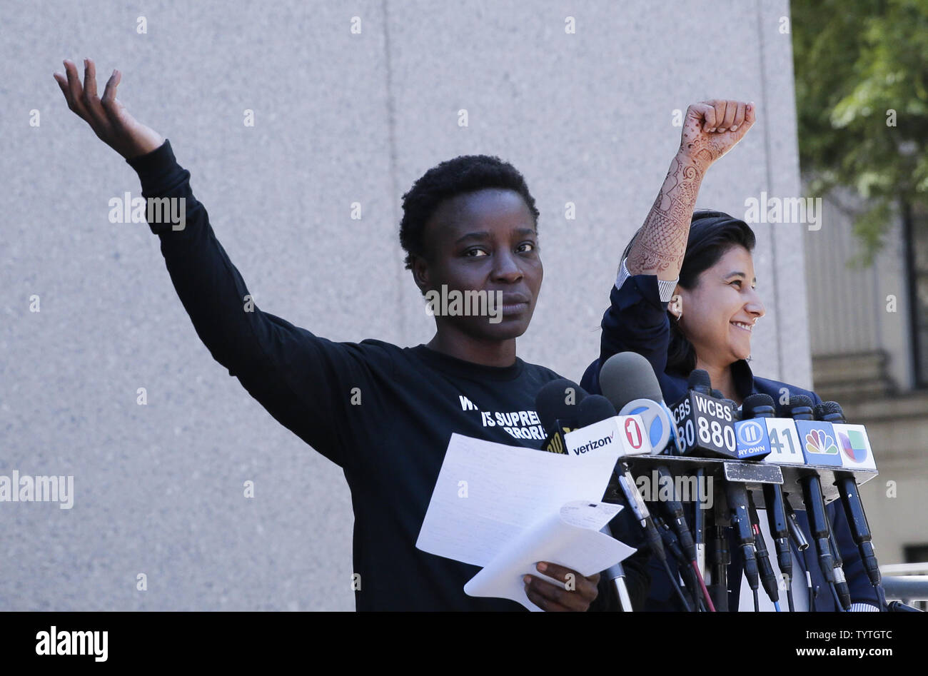 Statue Of Liberty climber and Rise and Resist protester Therese Okoumou raises her hand with Attorney Rhiya Trivedi when she speaks after exiting Court in New York City on July 5, 2018 in New York City. The woman who partially climbed up the Statue of Liberty on July 4th Independence Day and prompted authorities to evacuate Liberty Island was released without bail, and if convicted would face up to six months behind bars.    Photo by John Angelillo/UPI Stock Photo