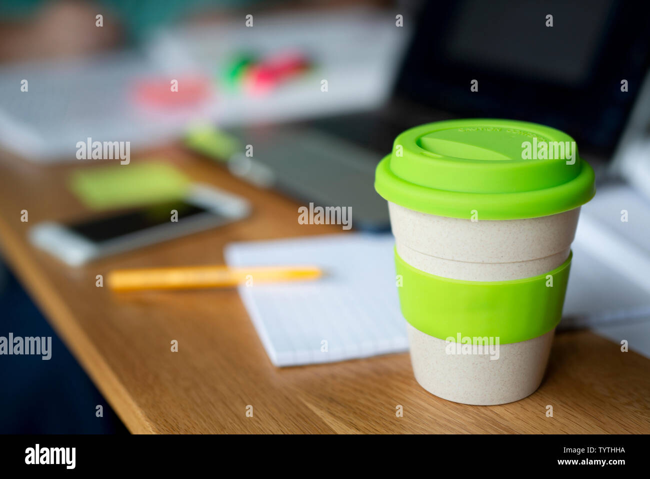 https://c8.alamy.com/comp/TYTHHA/a-bamboo-reusable-coffee-cup-sits-on-a-wooden-table-along-with-other-items-such-as-text-books-and-a-laptop-which-suggests-its-somebodys-study-space-TYTHHA.jpg