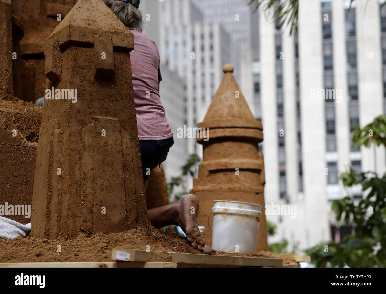 Workers build a 16foottall sand castle made of 16 tons of sand in the Channel Gardens at