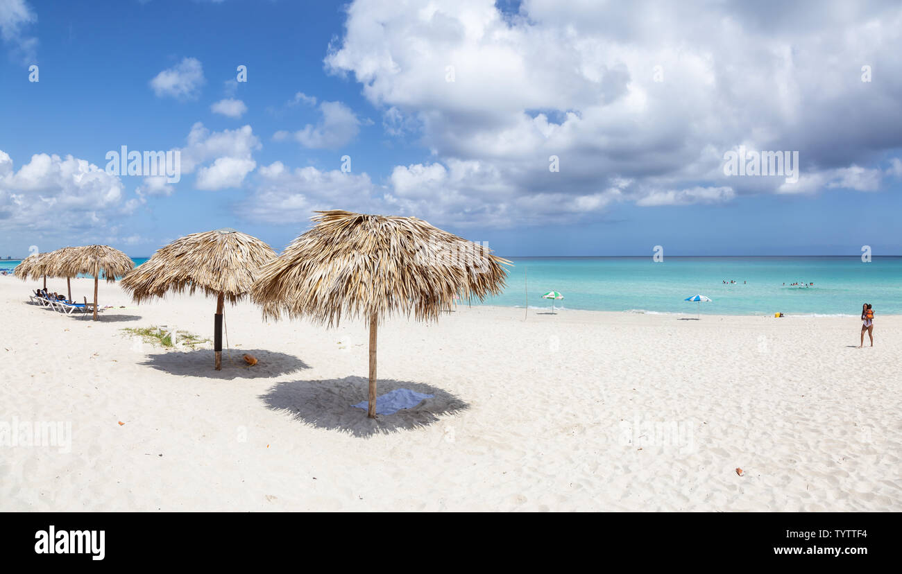 Varadero, Cuba - May 8, 2019: Beautiful panoramic view of the sandy beach underneath a shade umbrella during a vibrant sunny day. Stock Photo