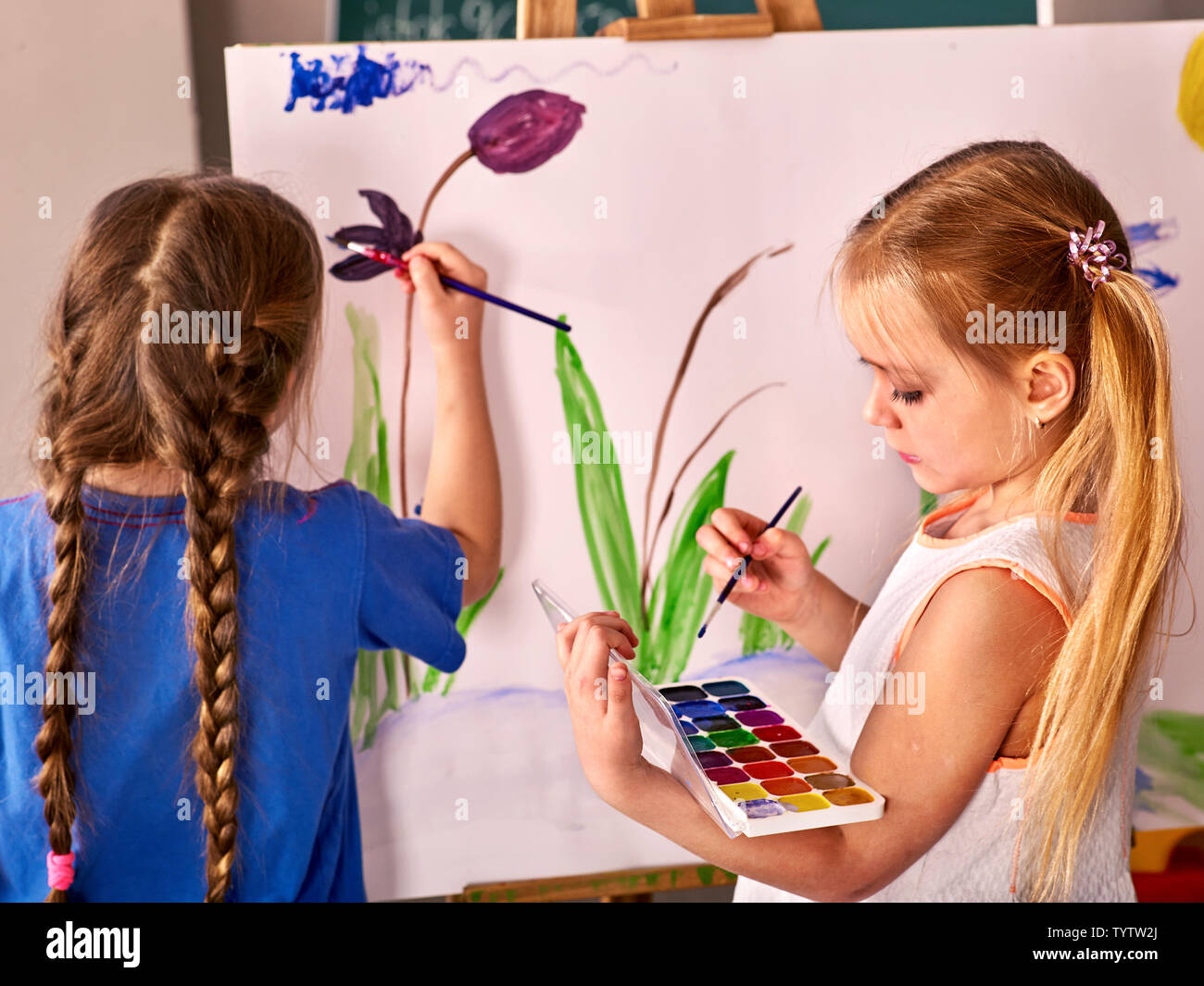 Children paint on an easel Stock Photo - Alamy