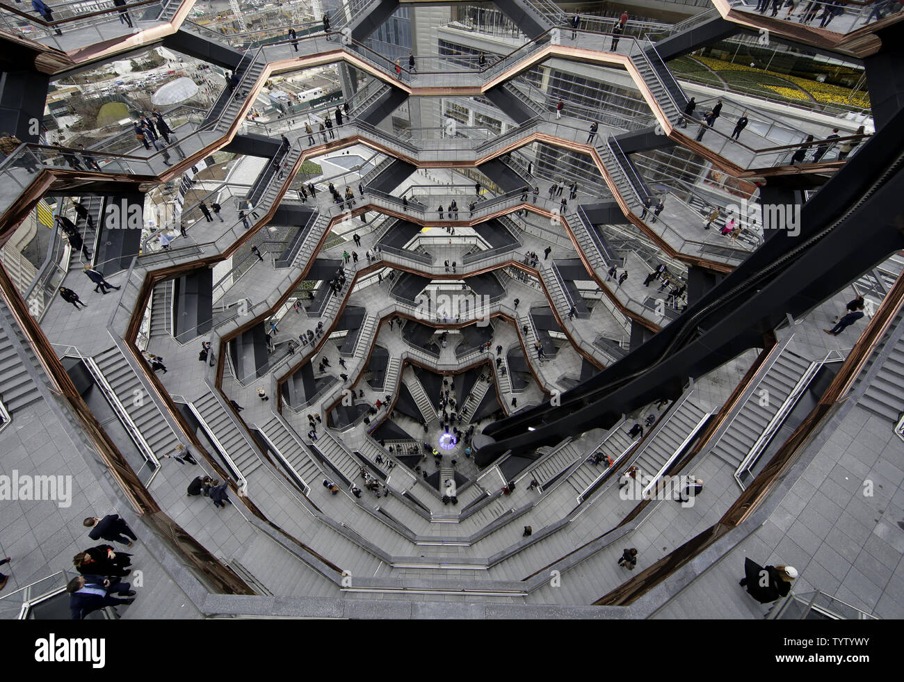 People walk through The Vessel at the Grand Opening of Hudson Yards in New York City on March 15, 2019. A towering sculpture called Vessel made up of 2,500 twisting steps the public can climb is scheduled to open Friday as the visual centerpiece of Hudson Yards which is a $25 billion urban complex on Manhattan's West Side that is the city's most ambitious development since the rebuilding of the World Trade Center. When fully complete, the 28-acre 11-hectare site will include 16 towers of homes and offices, a hotel, a school, the highest outdoor observation deck in the Western Hemisphere, a per Stock Photo