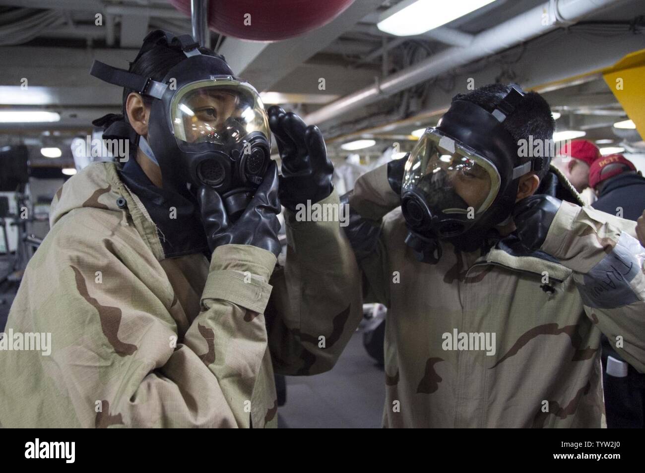 SASEBO, Japan (Nov. 30, 2016) Petty Officer 3rd Class Laniece Watters  (left), from Columbus, Ohio, and Petty Officer 2nd Class David Sacdal, from  San Francisco, Calif., don MCU-2P gas masks during a