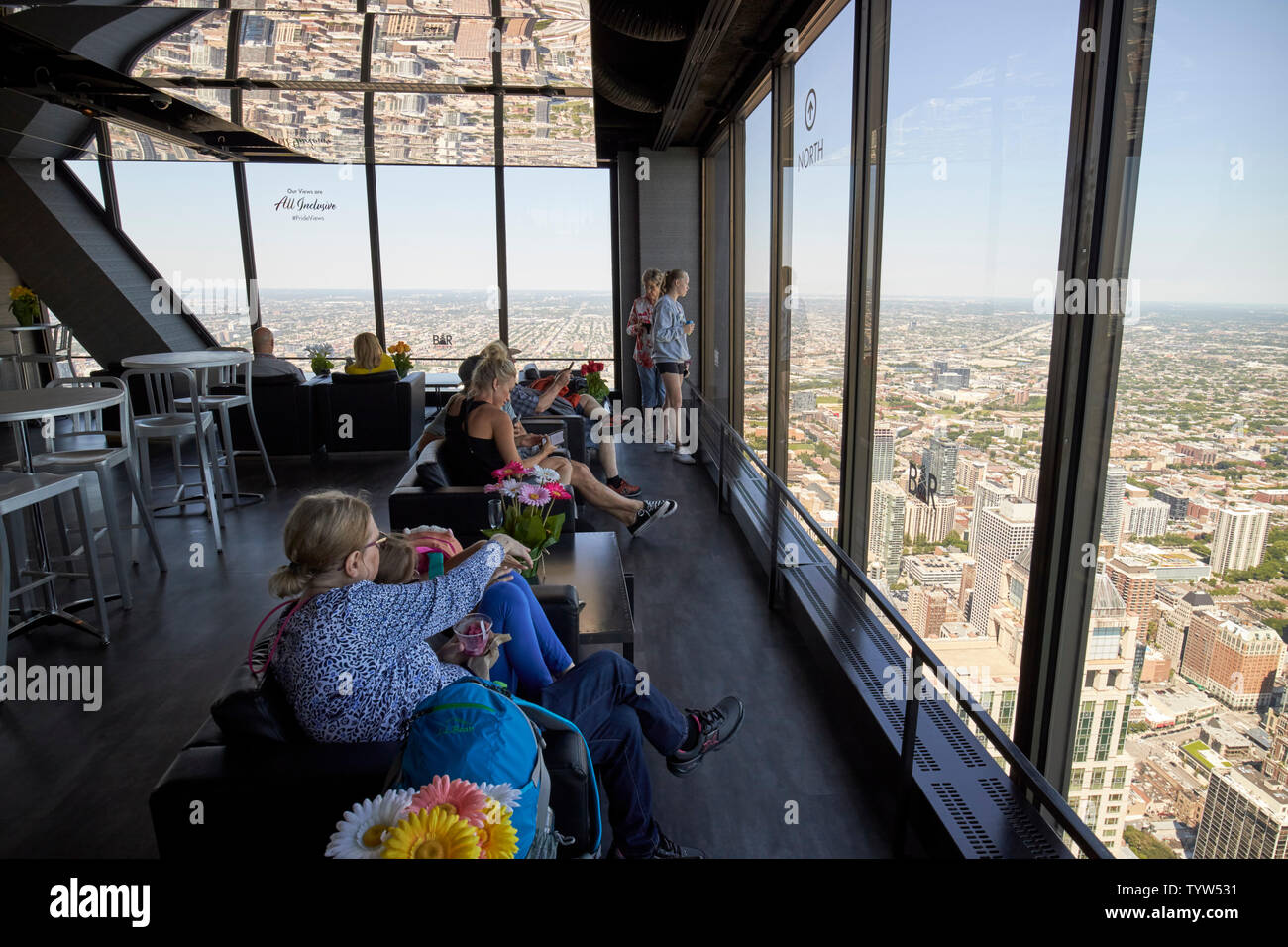 visitors looking out from the bar area of the observation deck of 360 chicago the john hancock building Chicago IL USA Stock Photo