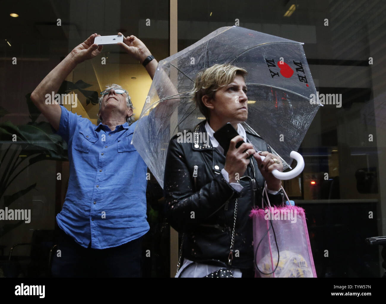 Spectators take photos as they stand outside the site where a ...