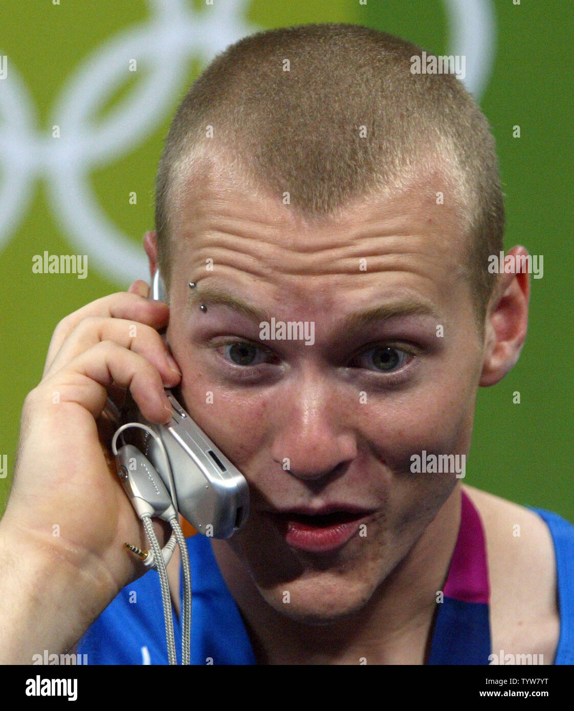 Canadian gymnast Kyle Shewfelt takes a call from Paul Martin, the prime minister of Canada, after winning the country's first gold medal at the Olympic Games. Shewfelt, of Calgary, won the floor exercises finals in a tie-breaker with Romania's Marian Dragulescu at the Athens Olympic Indoor Hall on August 22, 2004.  (UPI Photo / Grace Chiu) Stock Photo