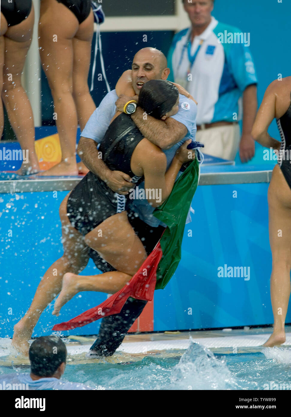 A member of the Italian women's team pulls one of the coaching staff into  the pool while celebrating their gold medal win over Greece in the Water  Polo final at the Olympic