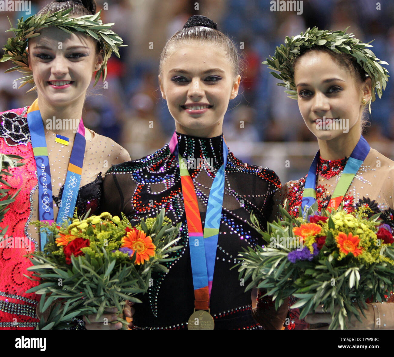 Medallists in the Olympic rhythmic gymnastics individual all around competition smile at Galatsi Hall in Athens on August 29, 2004. From left, Anna Bessonova of Ukraine, bronze. 106.700 points; Alina Kabaeva of Russia, gold, 108.400 points; and Irina Tchachina of Russia, silver, 107.325 points. (UPI Photo/Grace Chiu) Stock Photo