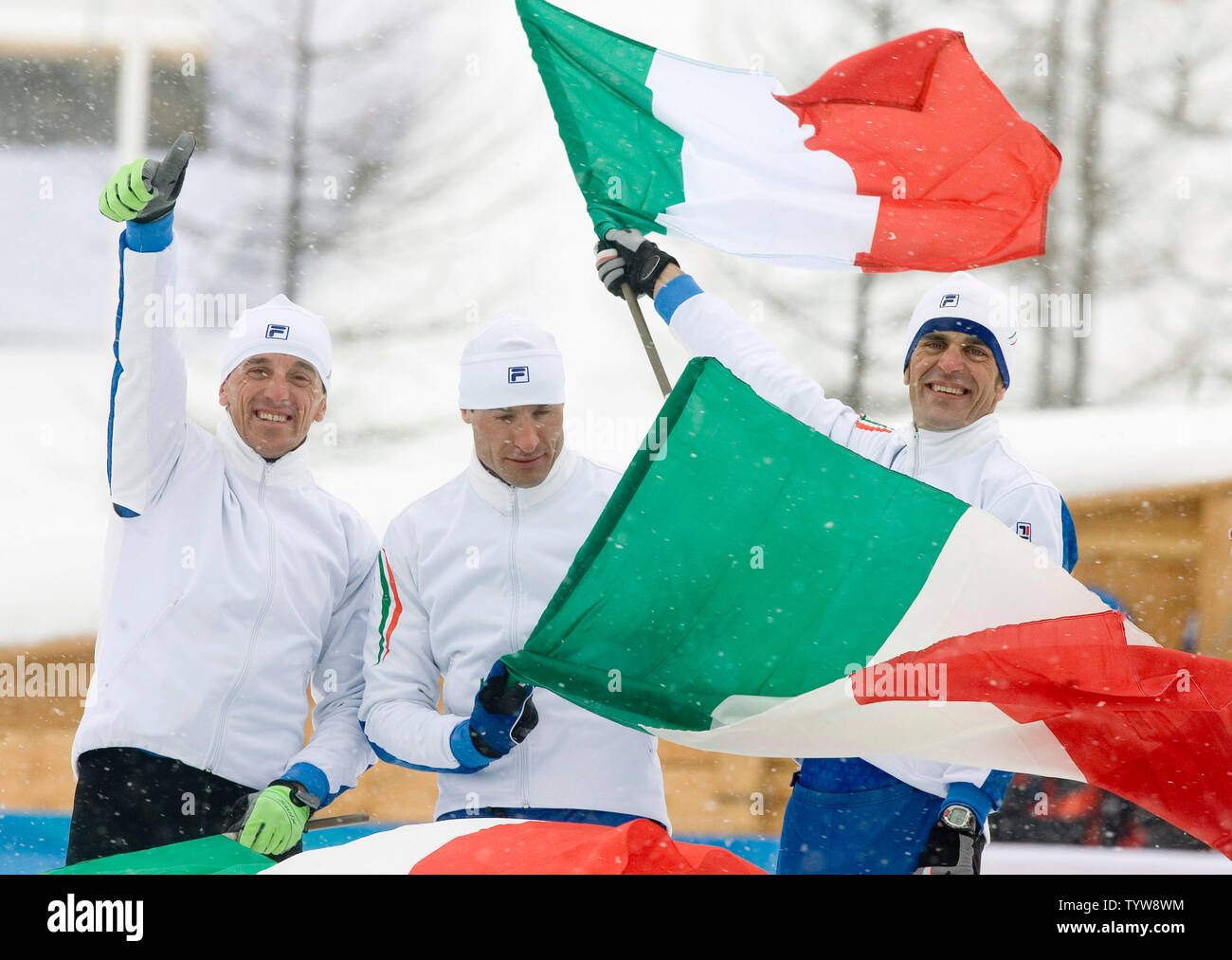 From the left, Italy's Fulvio Valbusa, Giorgio di Centa and Pietro Piller Cottrer celebrate while waiting for Cristian Zorzi to arrive to the podium after they win gold in men's 4x10km relay of cross country skiing at Pragelato Plan in the 2006 Torino Winter Olympic Games, February 19, 2006.  (UPI Photo/Heinz Ruckemann) Stock Photo