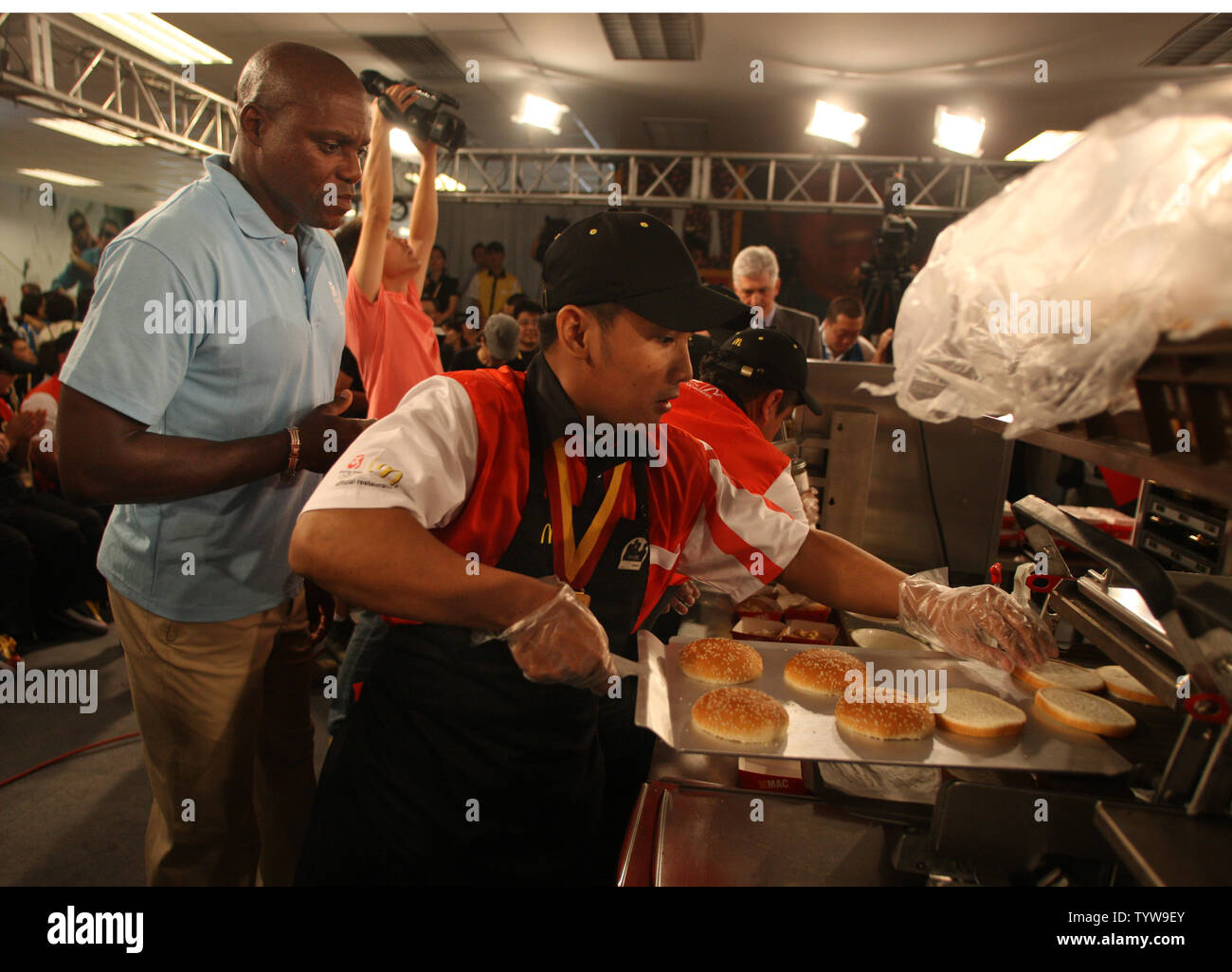 Carl Lewis (L), winner of 9 Olympic gold medals, coaches a team in a Big Mac building competition of employees from around the world, at a new McDonald's on the Olympic Green in Beijing on August 7, 2008.  McDonald's is the official restaurant of the Olympic Games.  (UPI Photo/Terry Schmitt) Stock Photo