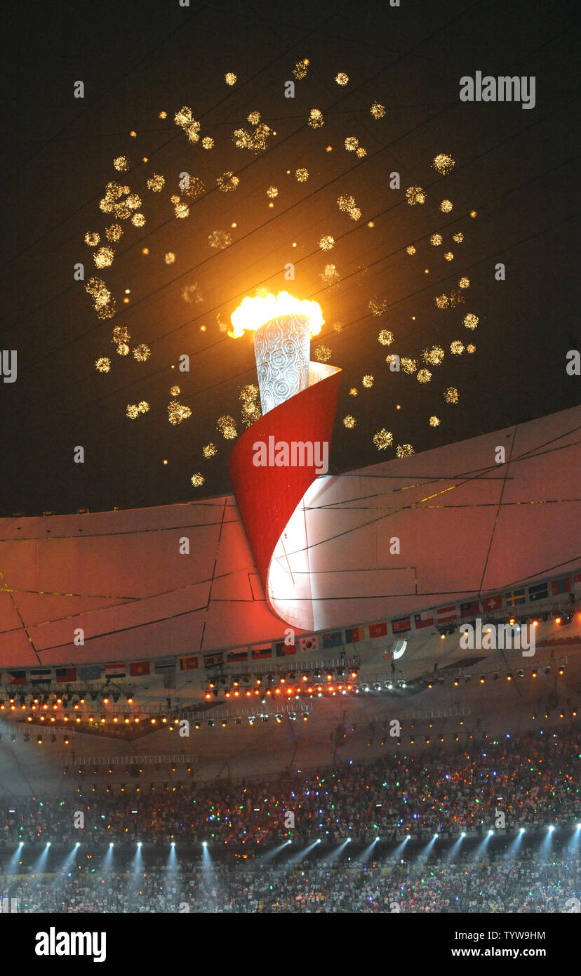Fireworks explodes behind the Olympic Flame atop the National Stadium during the Opening Ceremony of the 2008 Summer Olympics  in Beijing on August 8, 2008.  The Summer Games begin will run through August 24, 2008.   (UPI Photo/Pat Benic) Stock Photo