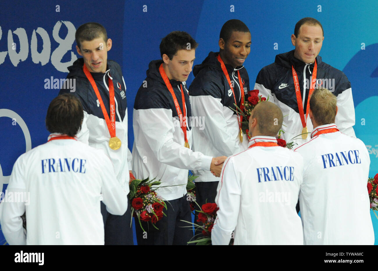 The French 4x100M Relay team congratulates the USA's gold medal team of (L-R) Michael Phelps, Garrett Weber-Gale, Cullen Jones and Jason Lezak during the awards ceremony at the National Aquatics Center at the Summer Olympics in Beijing on August 11, 2008.  The United States team won the gold in a World Record time of 3:08.24, nipping the French team by 0.07 second.    (UPI Photo/Pat Benic) Stock Photo