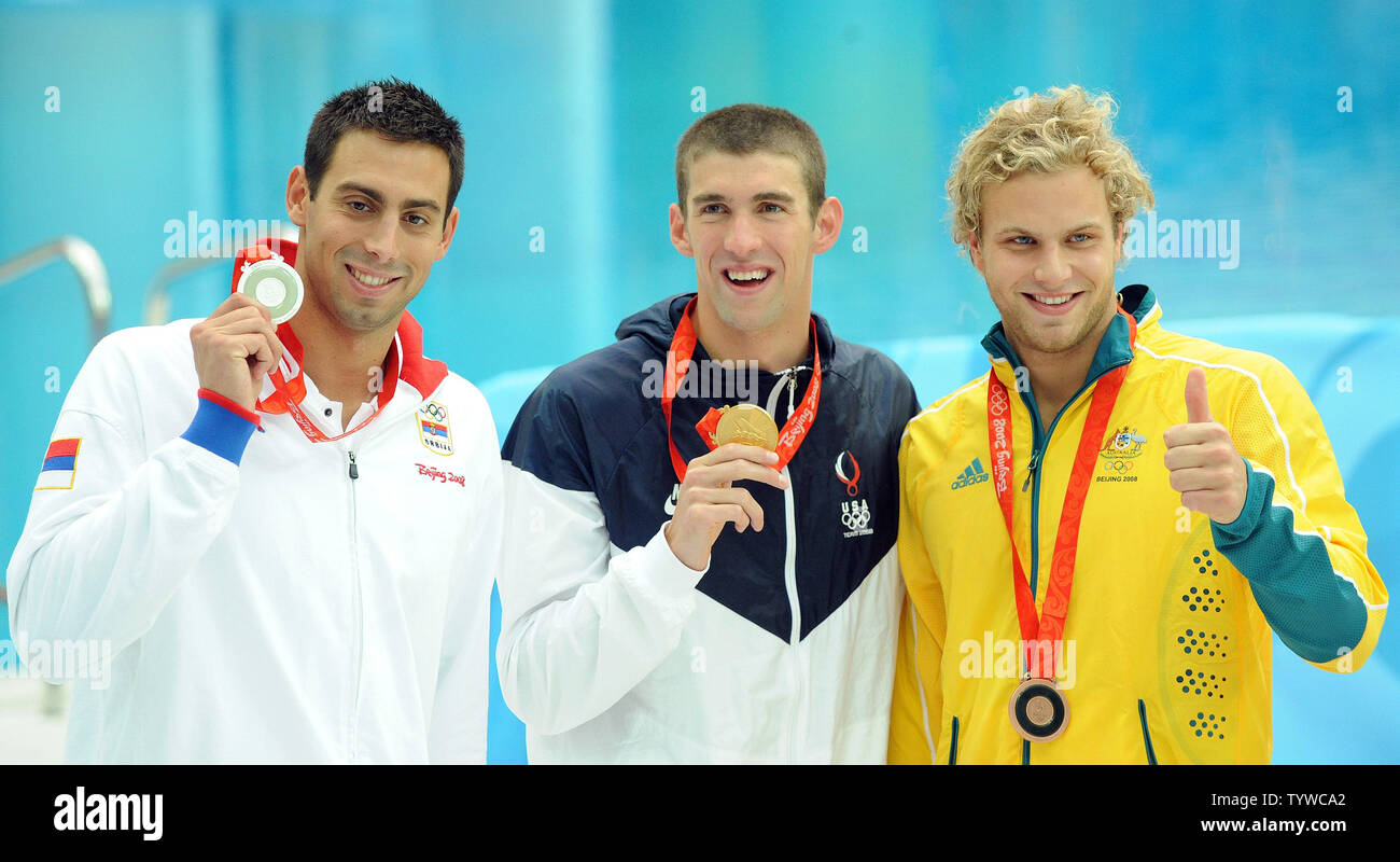 USA's Michael Phelps (C) holds up his 7th gold medal won in the Men's 100M Butterfly final at the National Aquatic Center (Water Cube) during the 2008 Summer Olympics in Beijing, China, on August 16, 2008. Phelps is tied with Mark Spitz, the swimmer who set the record for 7 gold medals in a single Olympics in Munich, 1972. At left is Serbian silver medalist Milorad Cavic, at right Australian bronze medalist Andrew Lauterstein.   (UPI Photo/Roger L. Wollenberg) Stock Photo