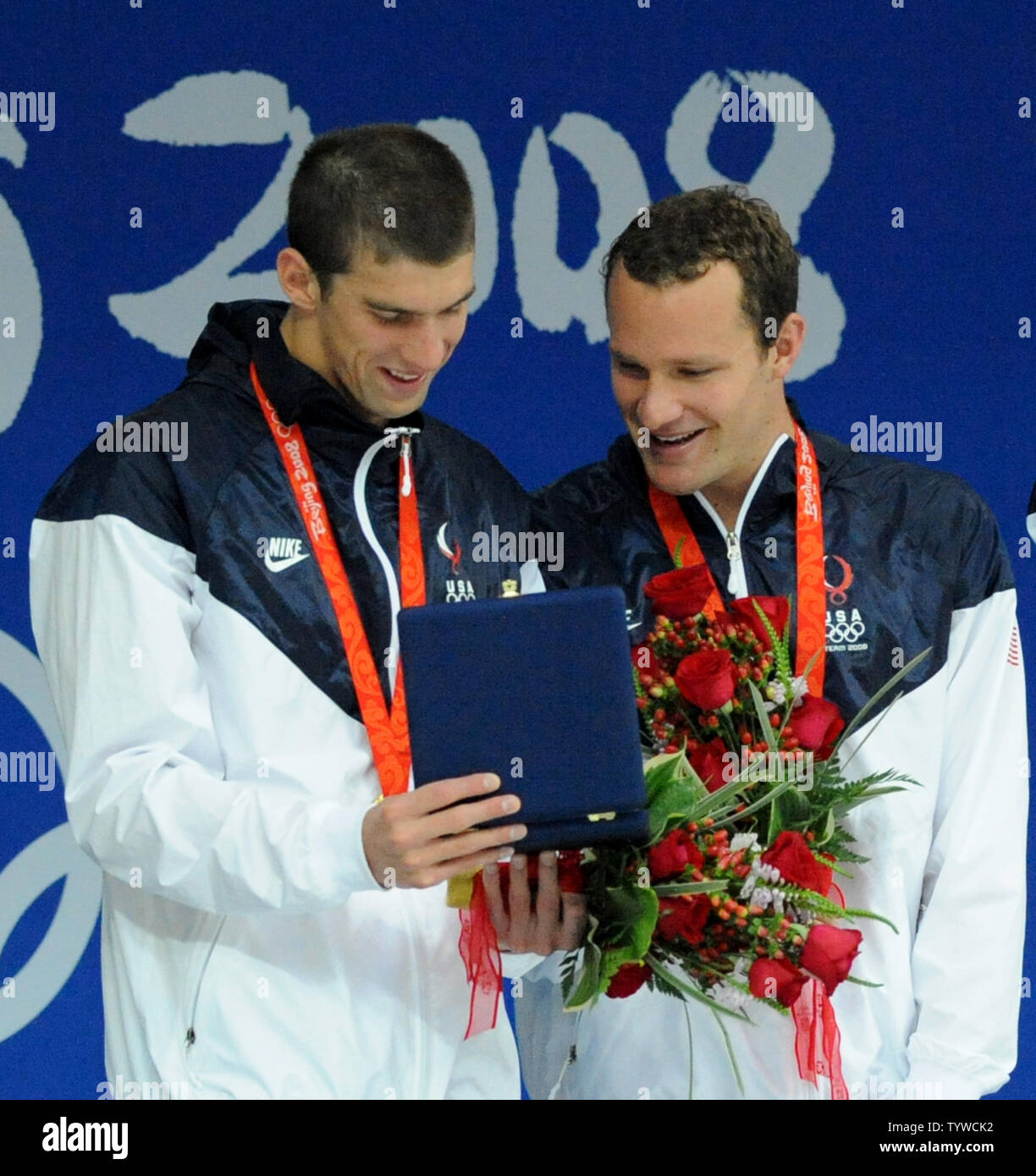 USA's Michael Phelps (L) looks at the special award to acknowledge that he set a new single Olympic record of eight gold medals with teammate Brendan Hansen during the awards ceremony for the Men's 4x100M Medley Relay event at the National Aquatics Center at the Summer Olympics in Beijing on August 17, 2008.   The USA team set a World Record of 3:29.34.     (UPI Photo/Pat Benic) Stock Photo