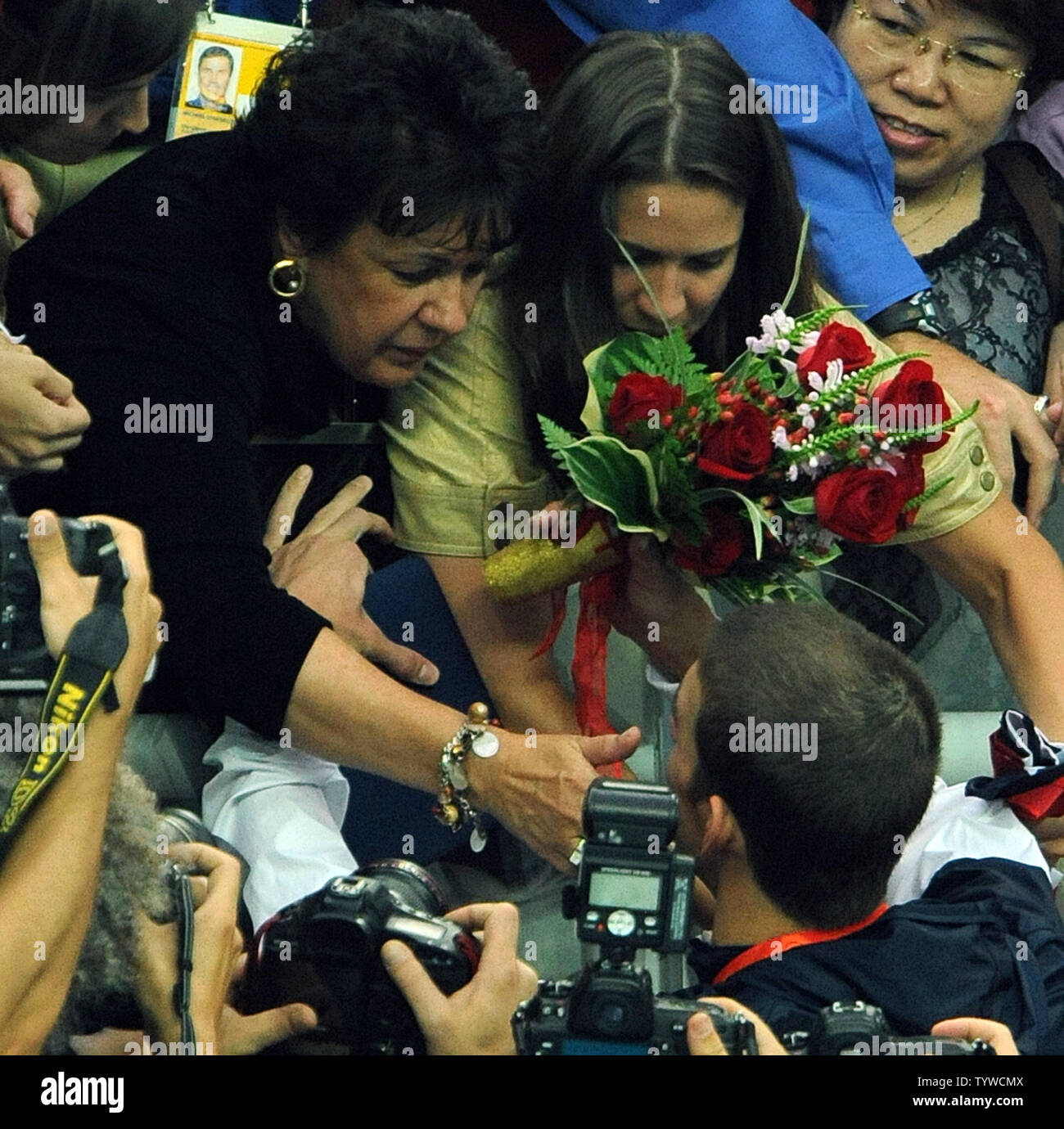 USA's Michael Phelps gives his flowers to his mother after the US team received their medals for the Men's 4x100M Medley, setting a world record of 3:29.34, at the National Aquatic Center (Water Cube) during the 2008 Summer Olympics in Beijing, China, on August 17, 2008.  Phelps set the world record for medals in a single Olympics with 8, passing Mark Spitz.    (UPI Photo/Roger L. Wollenberg) Stock Photo