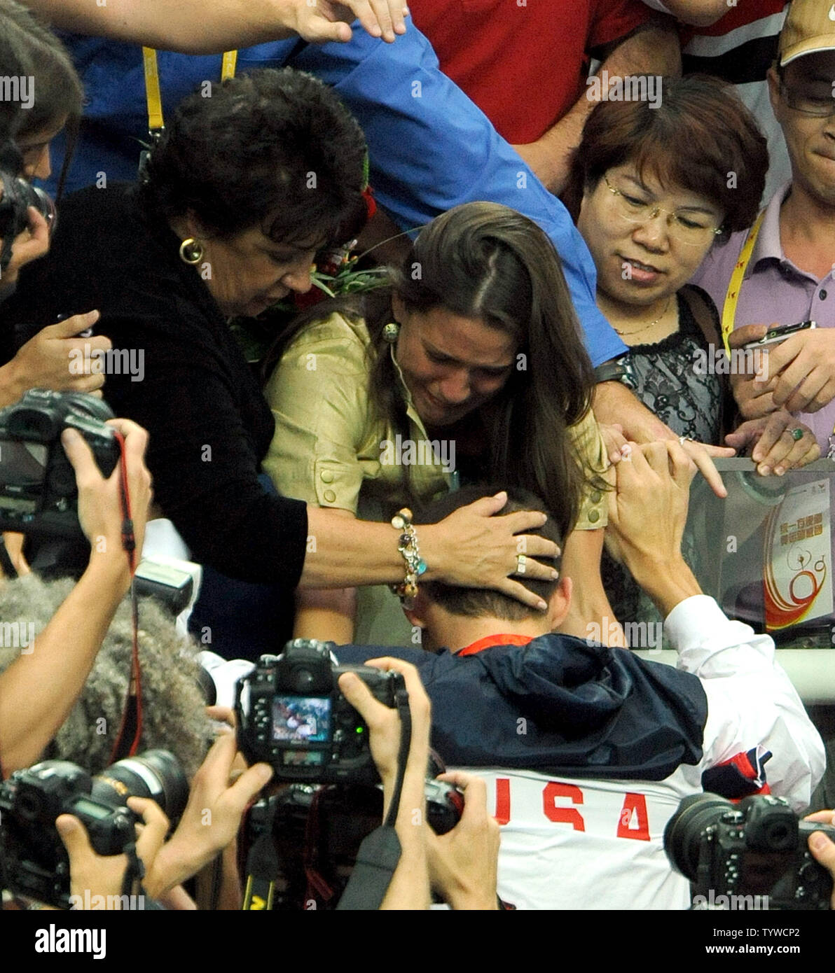 USA's Michael Phelps is congratulated by his mother, sister and others in the stands after the US team received their medals for the Men's 4x100M Medley, setting a world record of 3:29.34, at the National Aquatic Center (Water Cube) during the 2008 Summer Olympics in Beijing, China, on August 17, 2008.  Phelps set the world record for medals in a single Olympics with 8, passing Mark Spitz.    (UPI Photo/Roger L. Wollenberg) Stock Photo