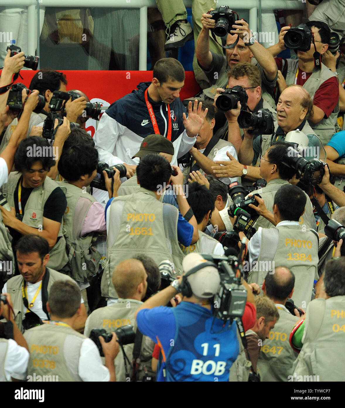 USA's Michael Phelps moves his way through photographers after climbing through them to see his mother and in the stands after the US team received their medals for the Men's 4x100M Medley, setting a world record of 3:29.34, at the National Aquatic Center (Water Cube) during the 2008 Summer Olympics in Beijing, China, on August 17, 2008.  Phelps set the world record for medals in a single Olympics with 8, passing Mark Spitz.    (UPI Photo/Roger L. Wollenberg) Stock Photo