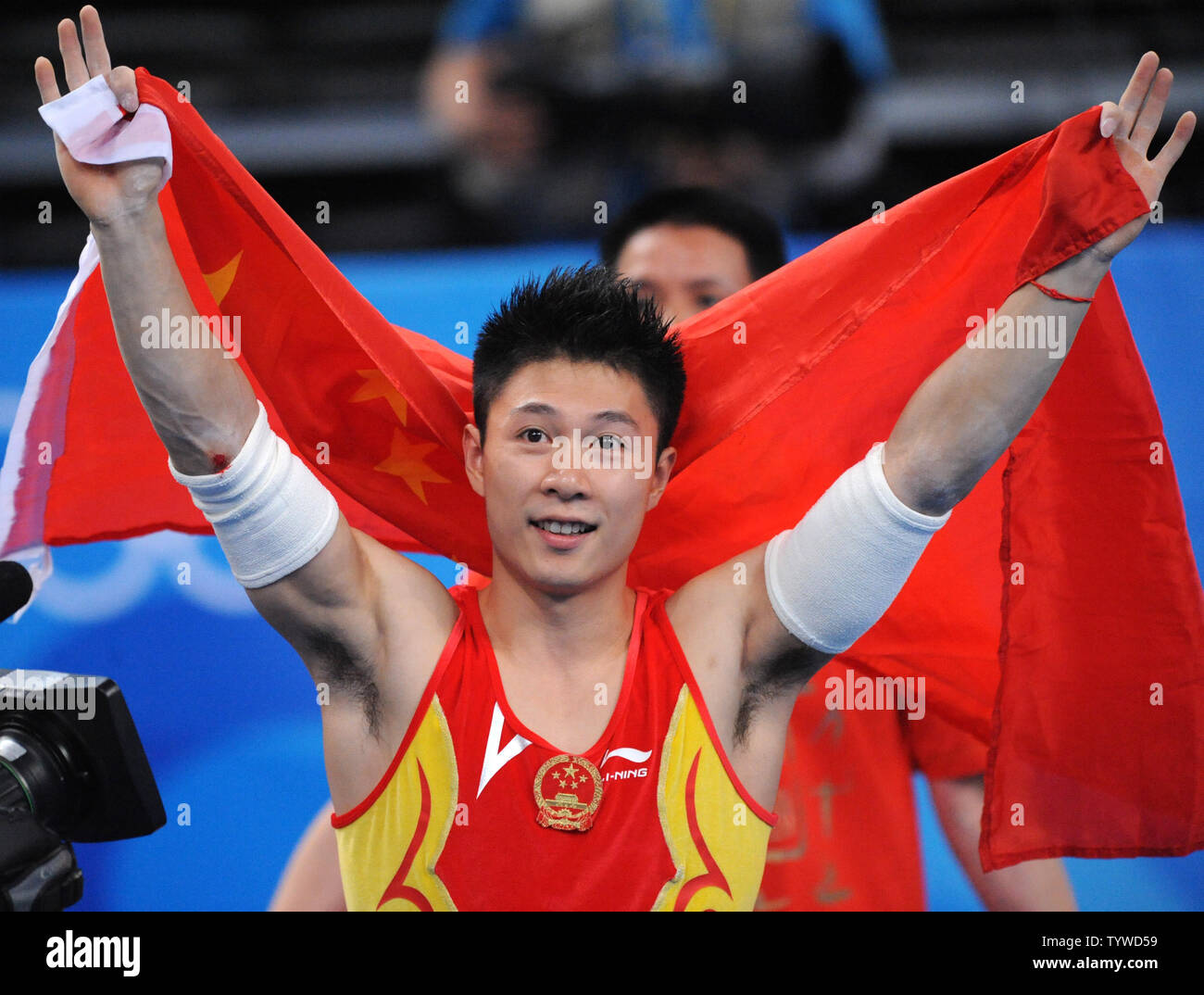 China's Li Xiaopeng holds a Chinese flag after winning the gold medal in the Men's Parallel Bars Finall in the apparatus finals at the National Indoor Gymnastics Stadium at the Summer Olympics in Beijing on August 19, 2008.   (UPI Photo/Pat Benic) Stock Photo