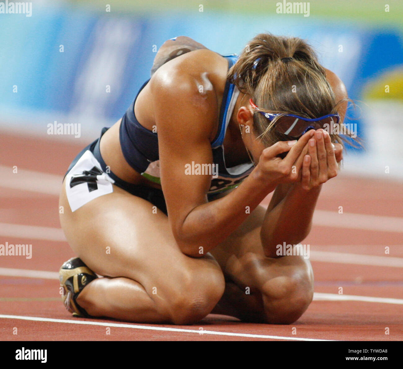 USA's Lolo Jones (3188) kneels on the track with her face in her hands