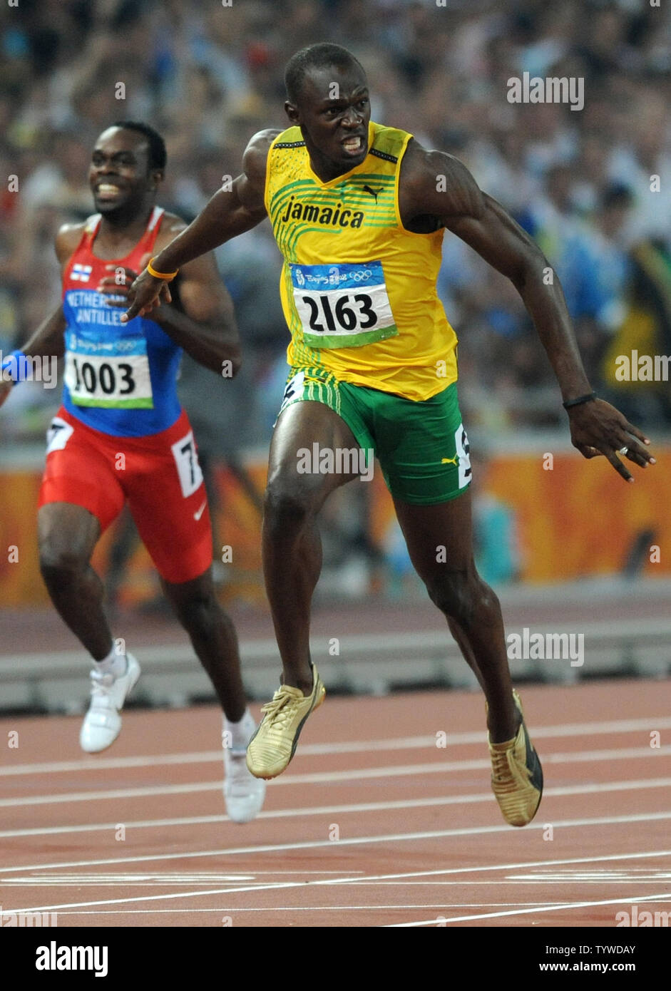 Jamaica's Usain Bolt jubilates stretches to cross the finish line ...