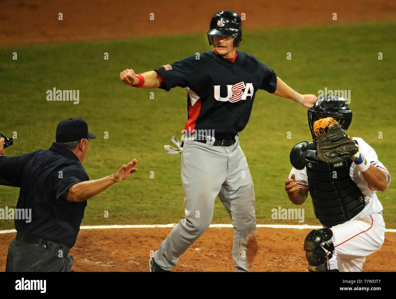 USA's Lou Marson (C) imitates umpire Juan Rodriegeuez Diaz's safe call at homeplate after he scored against Cuba's catcher Ariel Pestano during 5th inning action at Wukesong Baseball Field,  August 22, 2008, at the Summer Olympics in Beijing, China.  Cuba beat the USA team 10-2 and will face Korea for the gold medal.       (UPI Photo/Mike Theiler) Stock Photo
