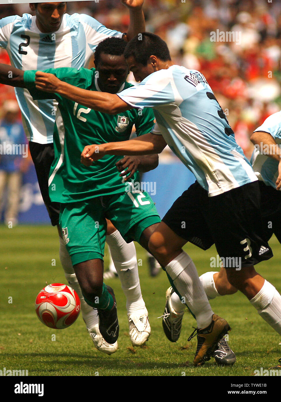Argentina's Ezequiel Garay (L) and teammate Luciano Monzon (R) try to steal the ball from Nigeria's Ebenezer Ajilore during the men's football final in the Beijing 2008 Olympic Games August 23, 2008.  Argentina won 1-0 for the gold, while Nigeria settled for the silver and Brazil the bronze.  (UPI Photo/Stephen Shaver) Stock Photo
