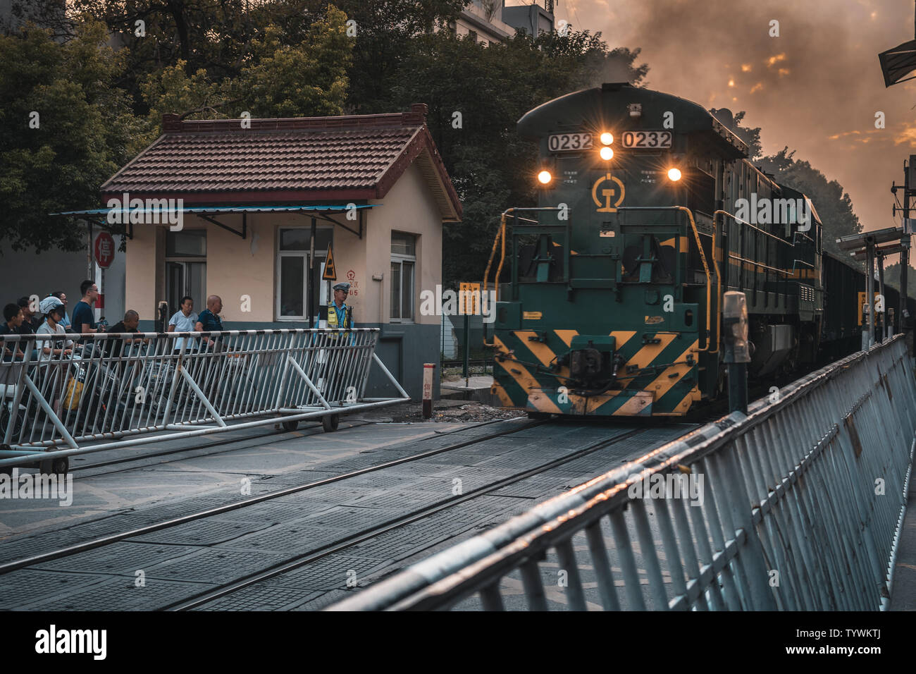 A freight railway outside Nanjing. In the evening, people on the street waited for a train to pass. Stock Photo