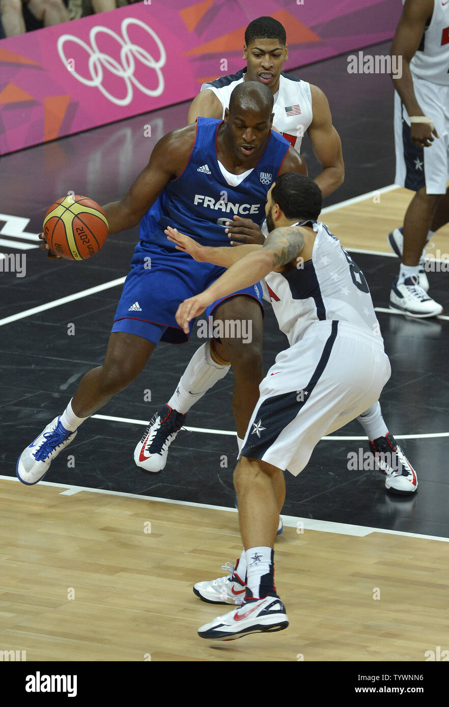 France's Ali Traore dribbles between the United States' Deron Williams, who also plays for the NBA's Brooklyn Nets (front) and Anthony Davis (rear), who also plays for the New Orleans Hornets during the United States-France Men's Basketball Preliminary competition at the 2012 Summer Olympics, July 29, 2012, in London, England.              UPI/Mike Theiler Stock Photo