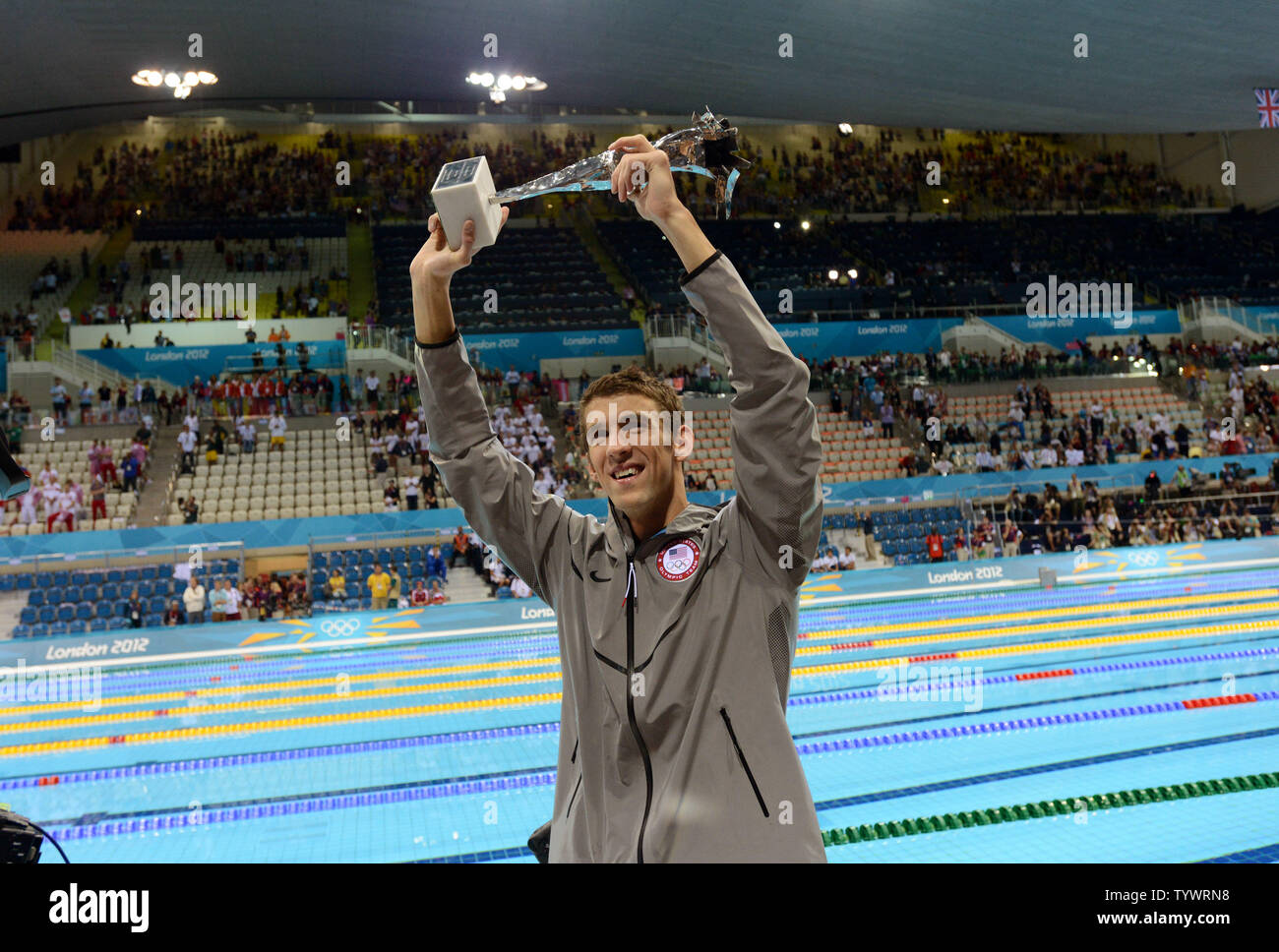 Michael Phelps holds a special Olympic recognition trophy after he won