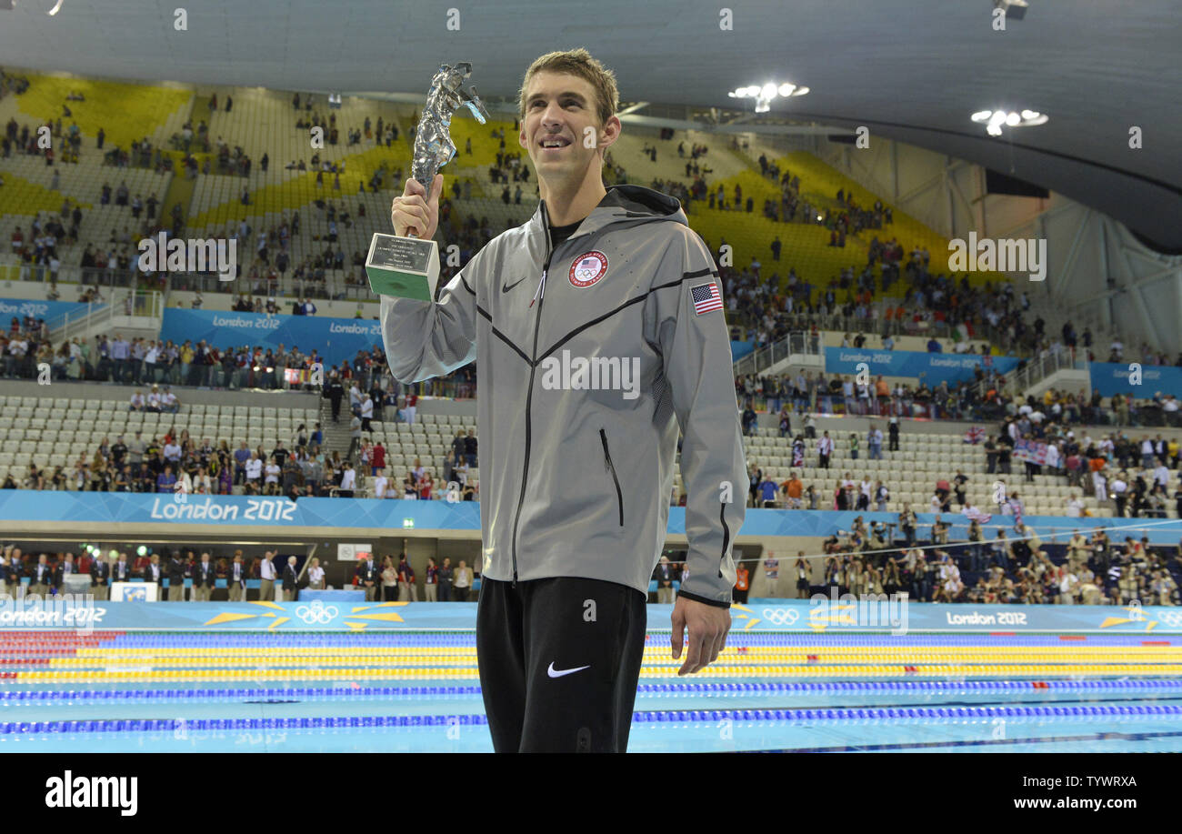 Michael Phelps Of The United States Holds A Trophy For The Most