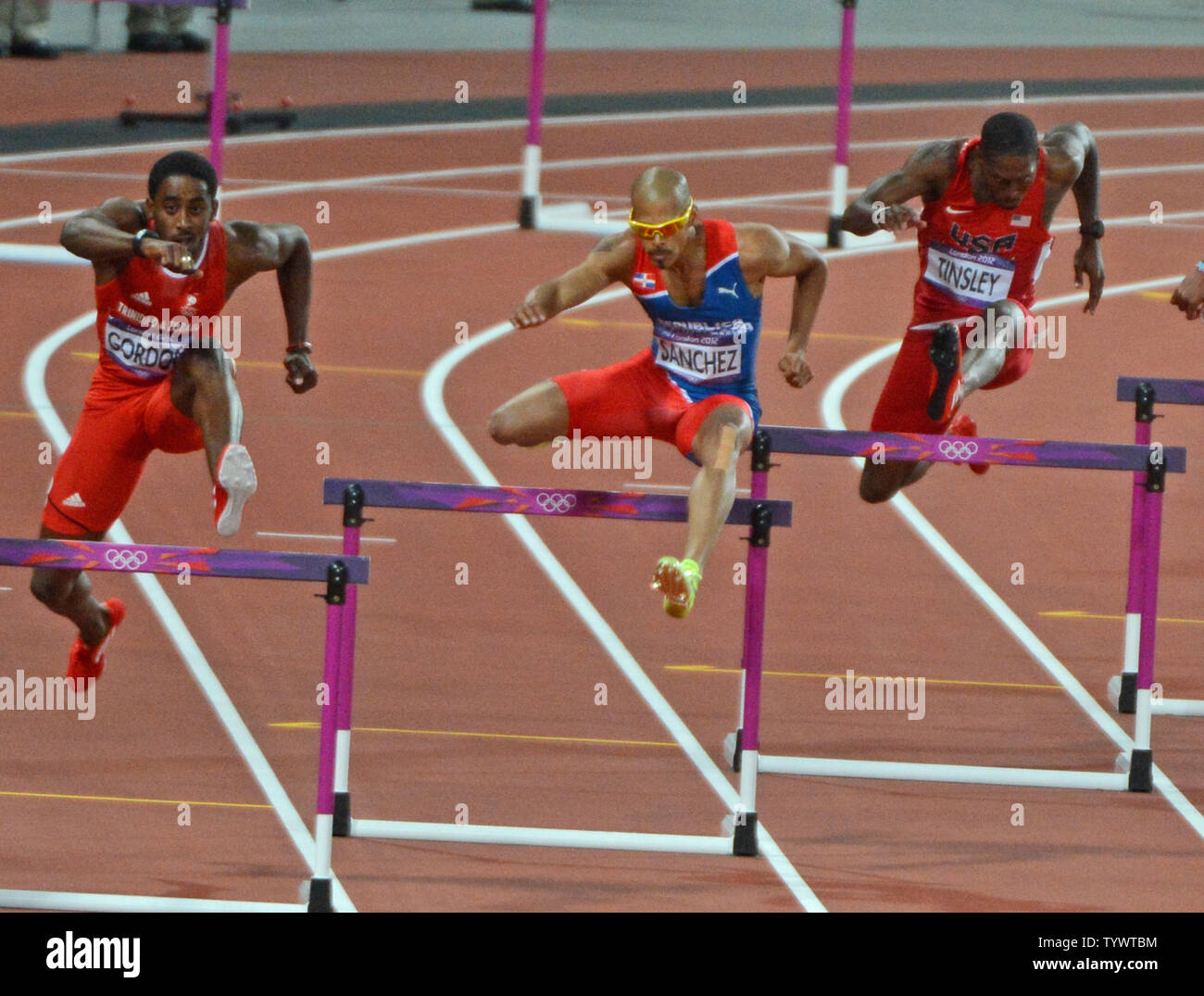 Felix Sanchez of the Dominican Republic (C) leaps a hurdle en route to