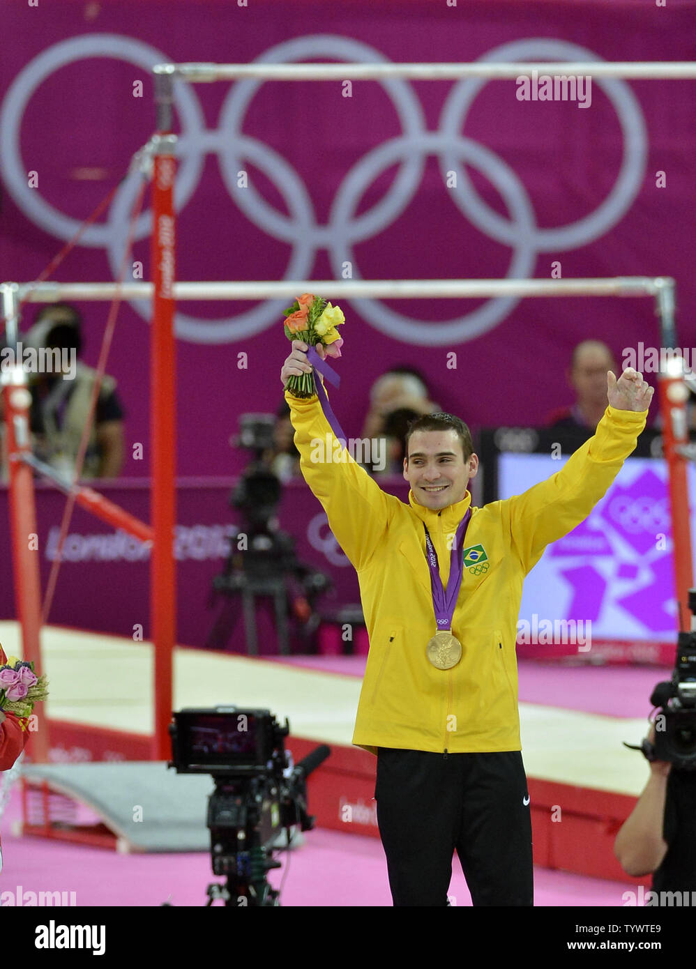Gymnastics gold medal winner for the Apparatus Finals on the rings, Brazil's Arthur Nabarette Zanetti, raises his hands in jubilation, during the awards ceremony, at the Greenwich North Arena at the 2012 Summer Olympics, August 6, 2012, in London, England.              UPI/Mike Theiler Stock Photo