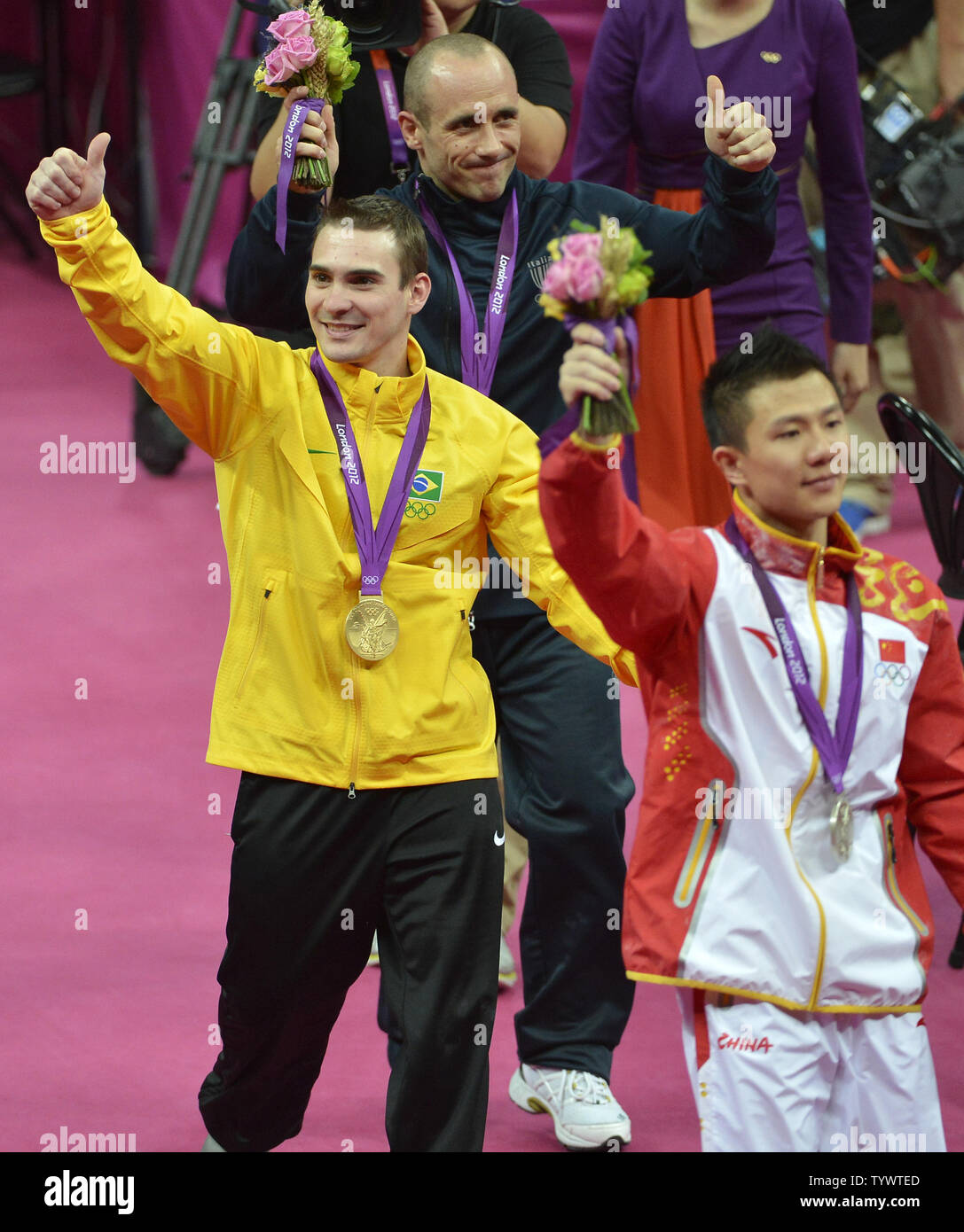 Gymnastics medal winners for the Apparatus Finals on the rings, Brazil's Arthur Nabarette Zanetti (gold medal), (L), China's Yibing Chen (silver medal), (R) and Italy's Matteo Morandi (bronze medal), wave to the fans during the awards ceremony, at the Greenwich North Arena at the 2012 Summer Olympics, August 6, 2012, in London, England.              UPI/Mike Theiler Stock Photo