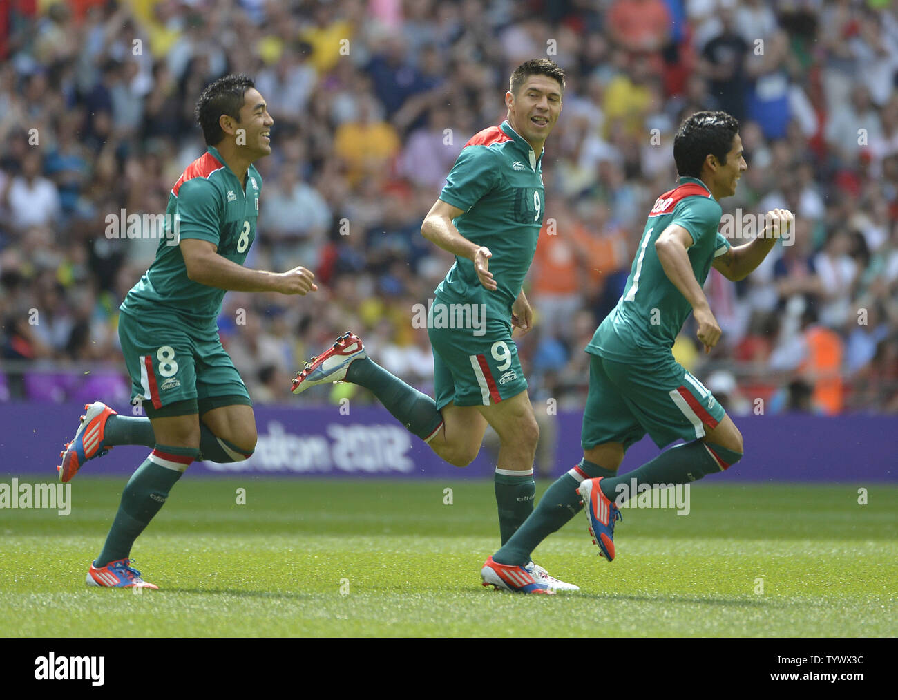 Marco Fabian (L-R) Oribe Peralta and Javier Aquino of Mexico celebrate Paralta's goal during the first half of the Gold Medal Football Match against Brazil at the London 2012 Summer Olympics on August 11, 2012 at Wembley Stadium, London.      UPI/Brian Kersey Stock Photo