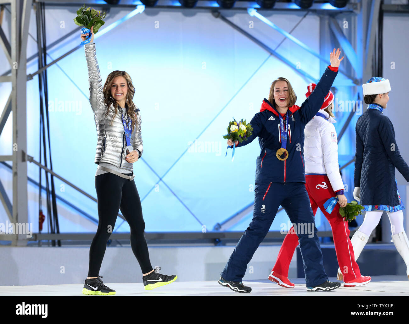 (From L to R) US athlete silver medalist Noelle Pikus-Pace and Great Britain's gold medalist Elizabeth Yarnold jubilate as they leave at the end of the medal ceremony for the women skeleton during the Sochi Winter Olympics on February 15, 2014.  UPI/Maya Vidon-White Stock Photo
