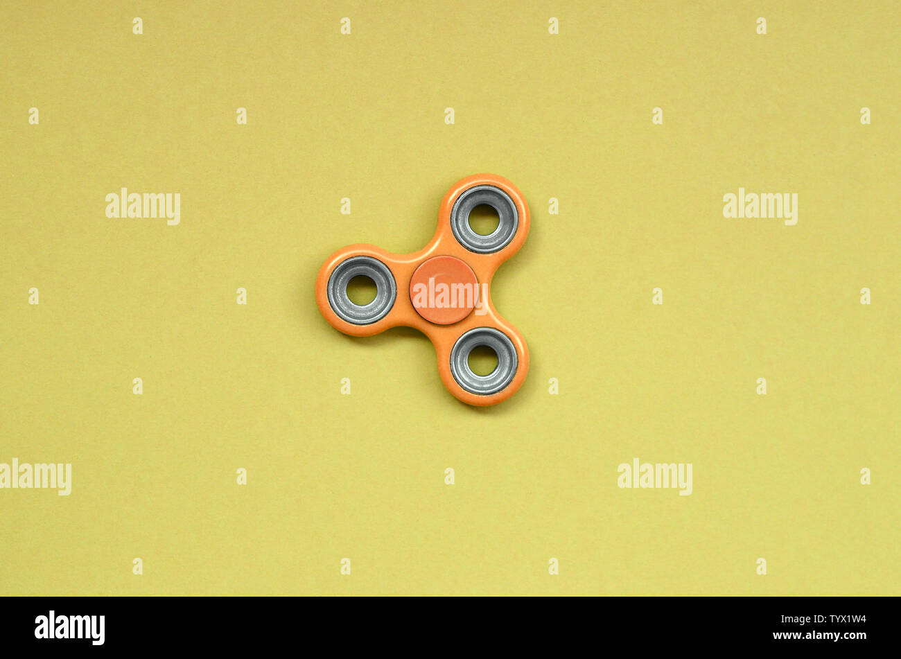 orange fidget spinner lies on texture background of fashion pastel orange  color paper in minimal concept Stock Photo - Alamy