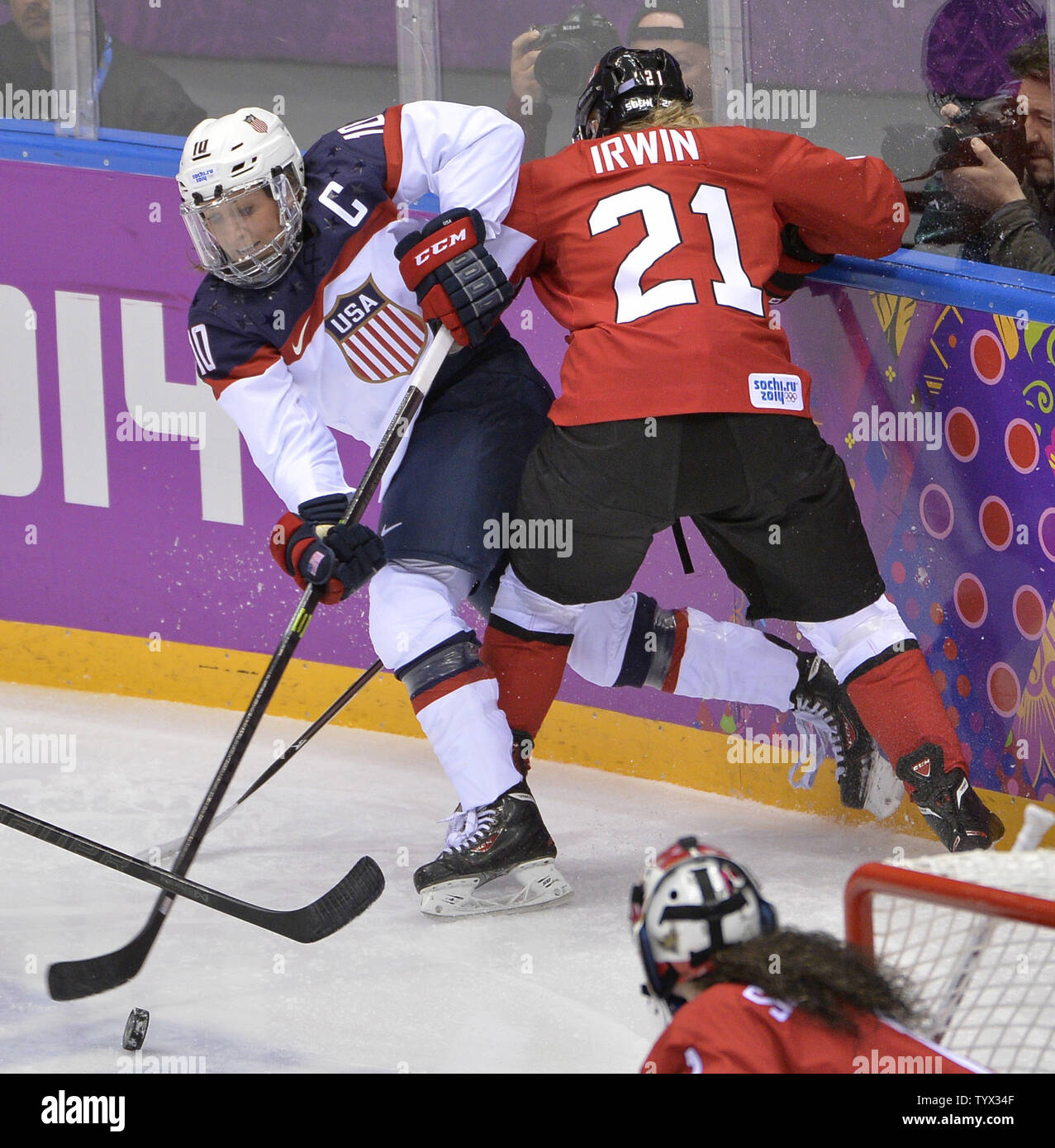 United States' Meghan Duggan (L) makes a pass as Canada's Haley Irwin defends during the first period of the women's gold medal ice hockey game at the Sochi 2014 Winter Olympics on February 20, 2014 in Sochi, Russia.     UPI/Brian Kersey Stock Photo