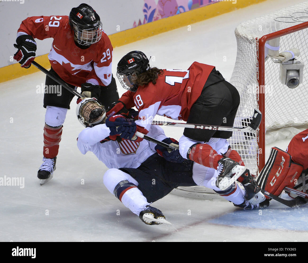 Canada's Catherine Ward cross checks United States' Anne Schleper during  overtime of the women's gold medal ice hockey game at the Sochi 2014 Winter  Olympics on February 20, 2014 in Sochi, Russia.