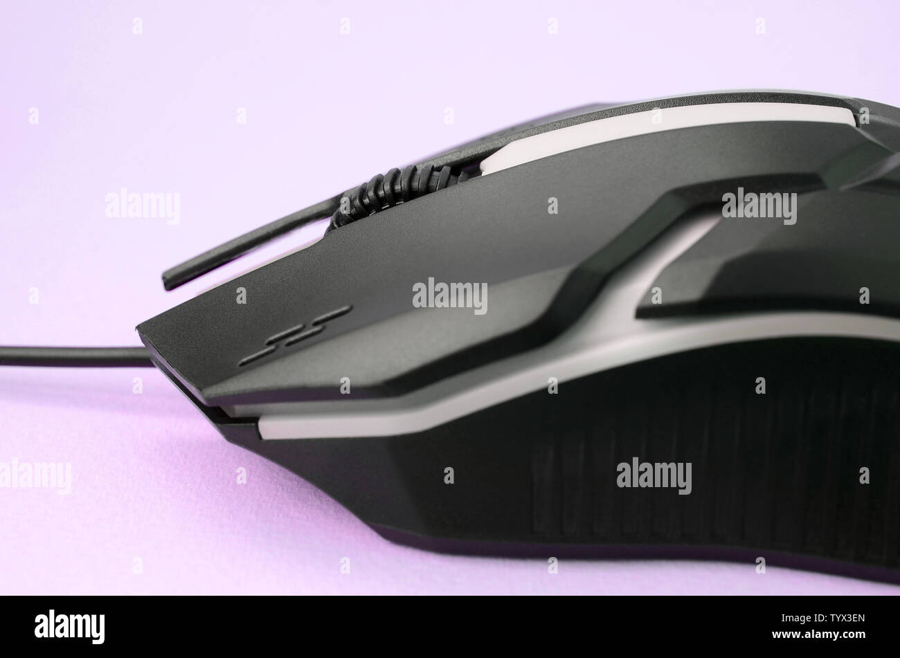 Closeup of a black gaming optical mouse on a pink background. Device ...