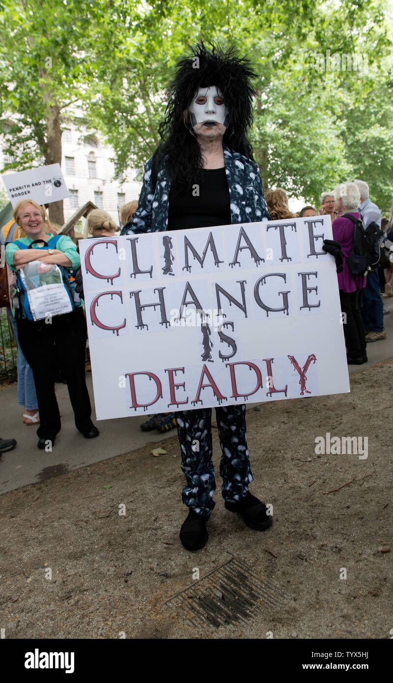 An Environmental protester holds a placard that says climate change is deadly during the demonstration.Environmental protesters gathered around Westminster to lobby politicians and tell them that actions need to be done for climate and environment. They also demanded the MP’s to pass new laws to reduce emissions and tackle plastic pollution. Stock Photo