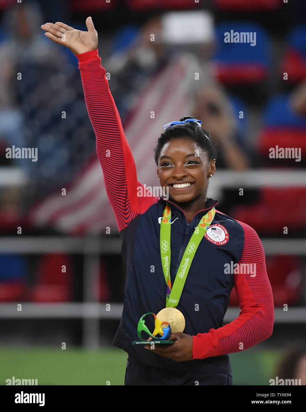 Simone Biles Waves Holding Her Gold Medal After Competeing At The Women 